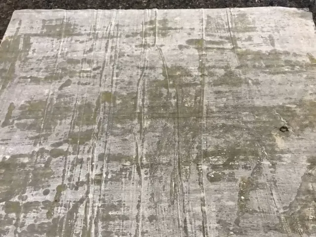 A sheet of fillo dough brushed with melted butter on a dark granite counter