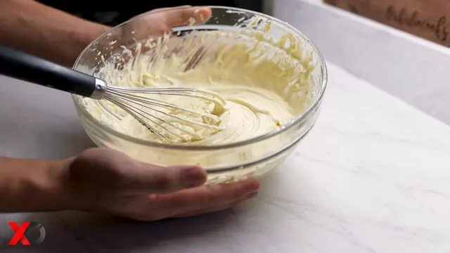 Mascarpone frosting whisked until creamy and fluffy in a glass bowl