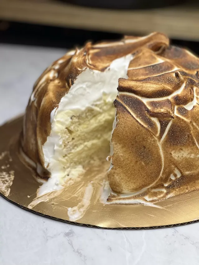 The torched Cipriani meringue cake with a slice cut out, showing the layers inside