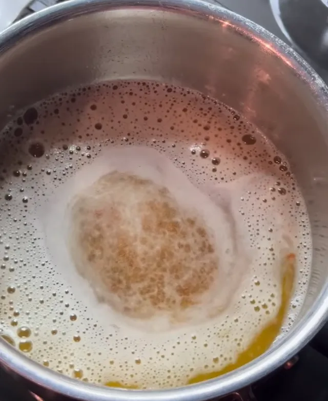 Butter foaming in a stainless steel saucepan as it starts to brown