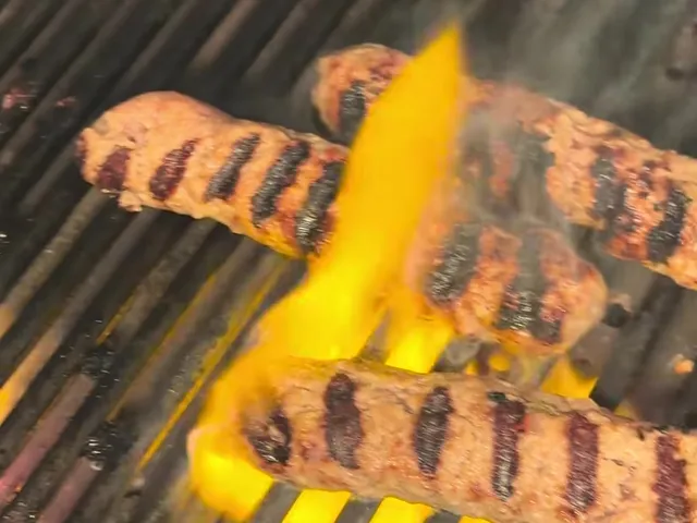 Kernacka with dark grill marks on a hot grill, with flames coming up between the grates