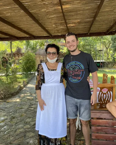 Xhulio with a woman in a white apron in a restaurant garden